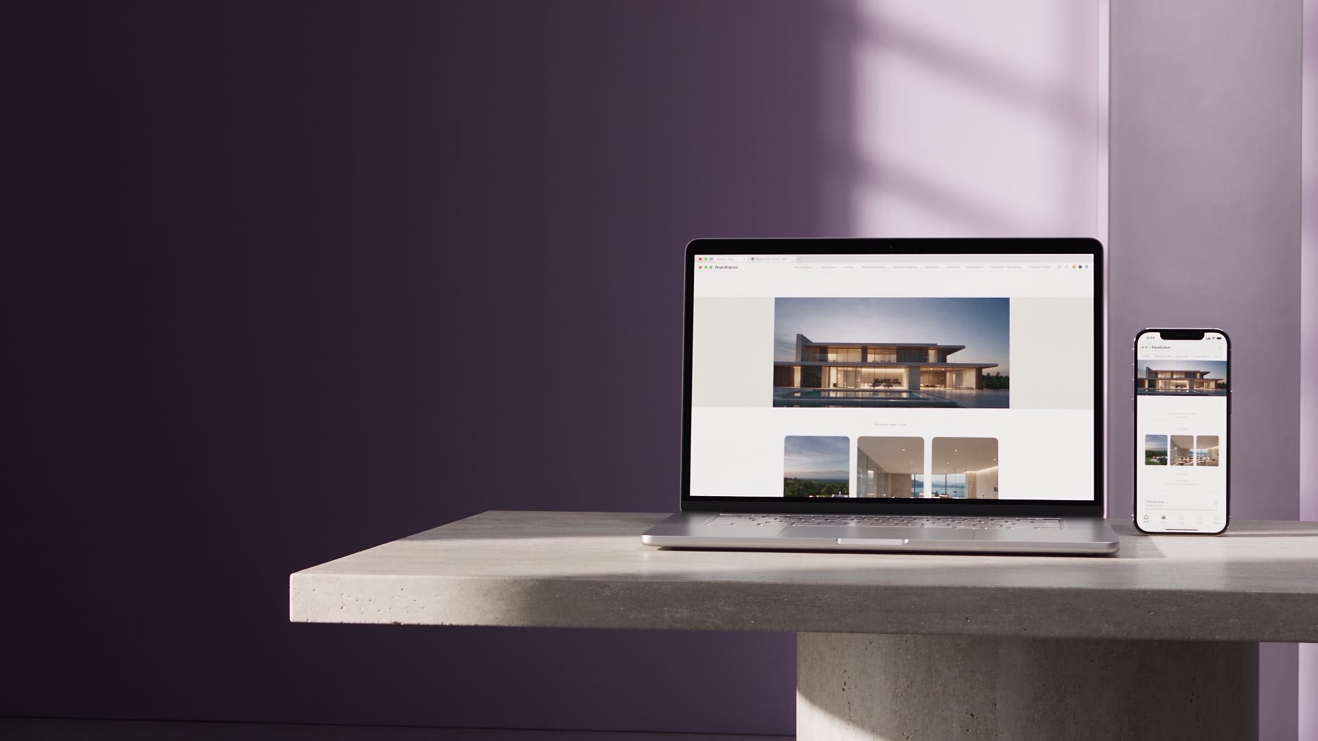 A titanium laptop and phone presenting a coordinated architectural website in a lavender studio